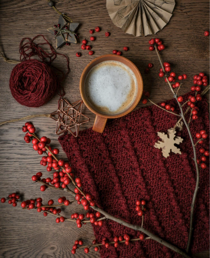 Image of frothy coffee surrounded by festive decor.